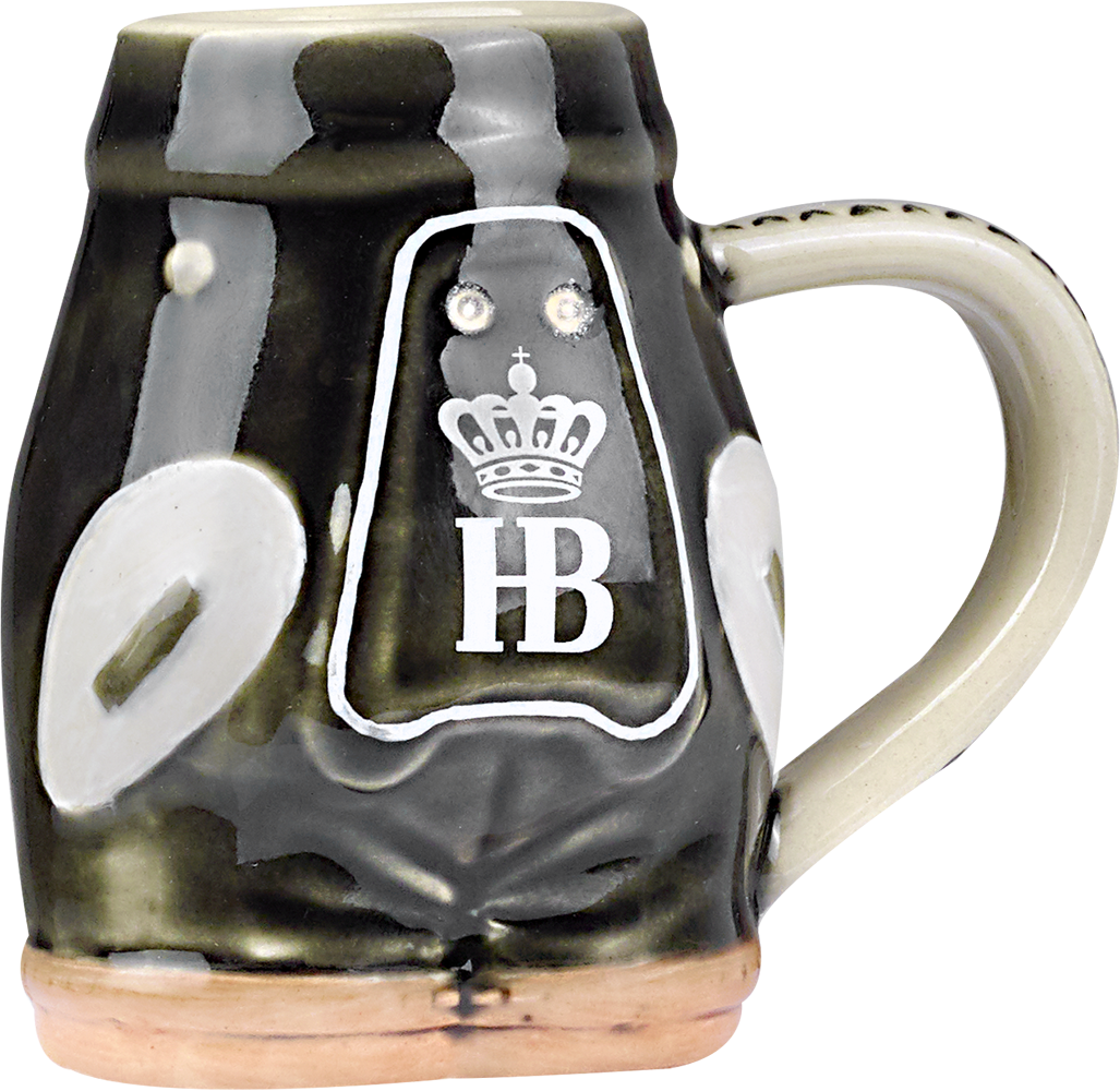 Steingut-Schnapsglas in Form einer Lederhose gestaltet. Das Glas ist bunt bemalt und zeigt eine braune Lederhose. Auf der Brust befindet sich das HB-Logo und einer Krone zu sehen. Seitlich befindet sich ein Henkel. Seitlicher Ansicht