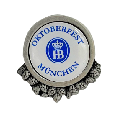 „Metallischer Ansteckpin mit rundem Design. In der Mitte befindet sich ein blauer Kreis mit weißen Buchstaben ‚HB‘. Um den Kreis herum verläuft der Schriftzug ‚OKTOBERFEST MÜNCHEN‘. Am unteren Rand sind dekorative Elemente eingearbeitet, die dem Pin ein f